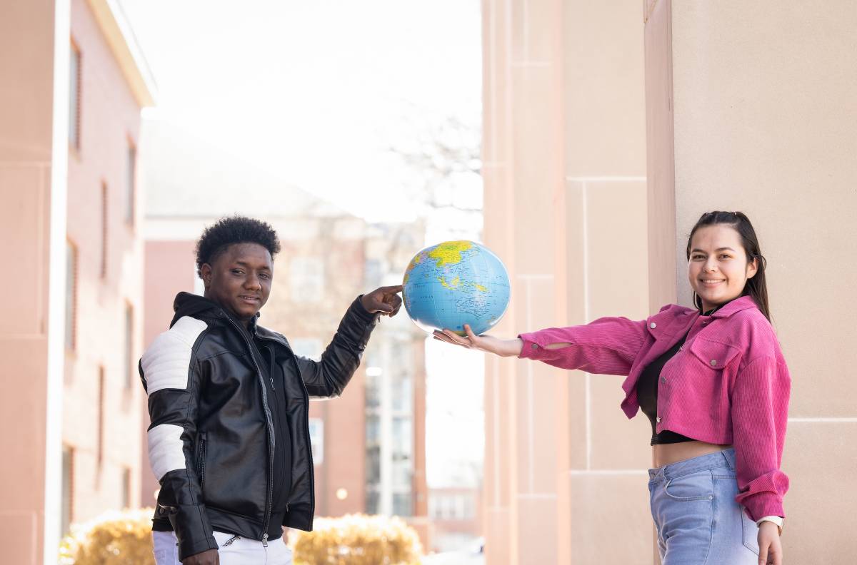 international students poiting at globe