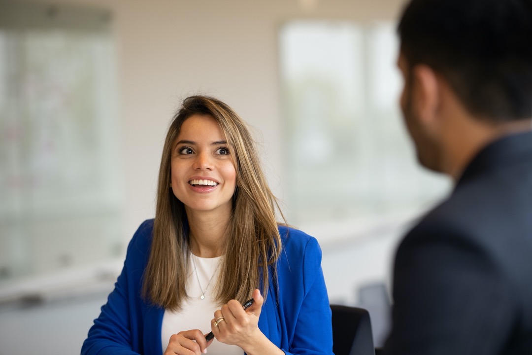 MBA student in blue jacket smiling at classmate