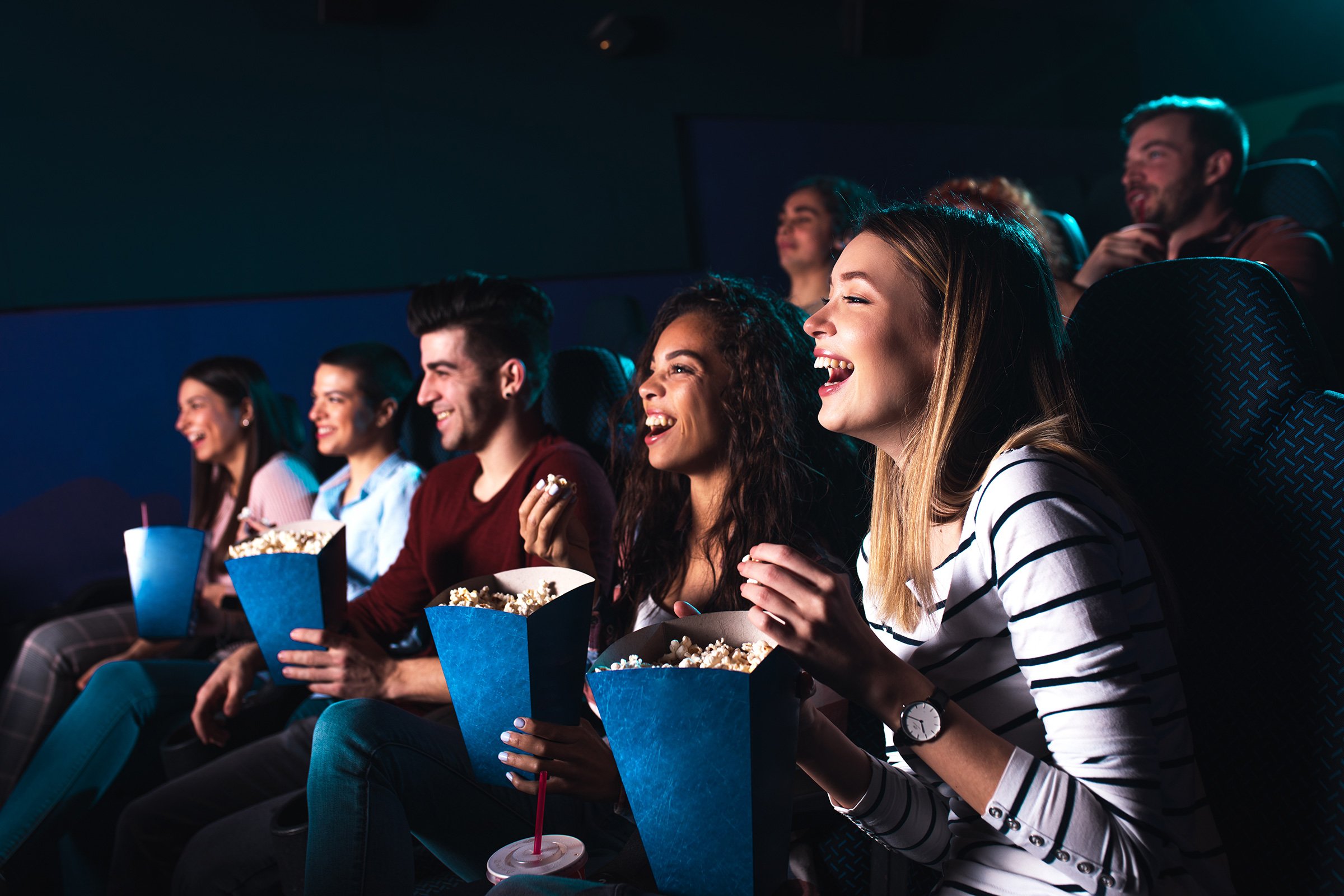 People enjoying movie with popcorn and friends