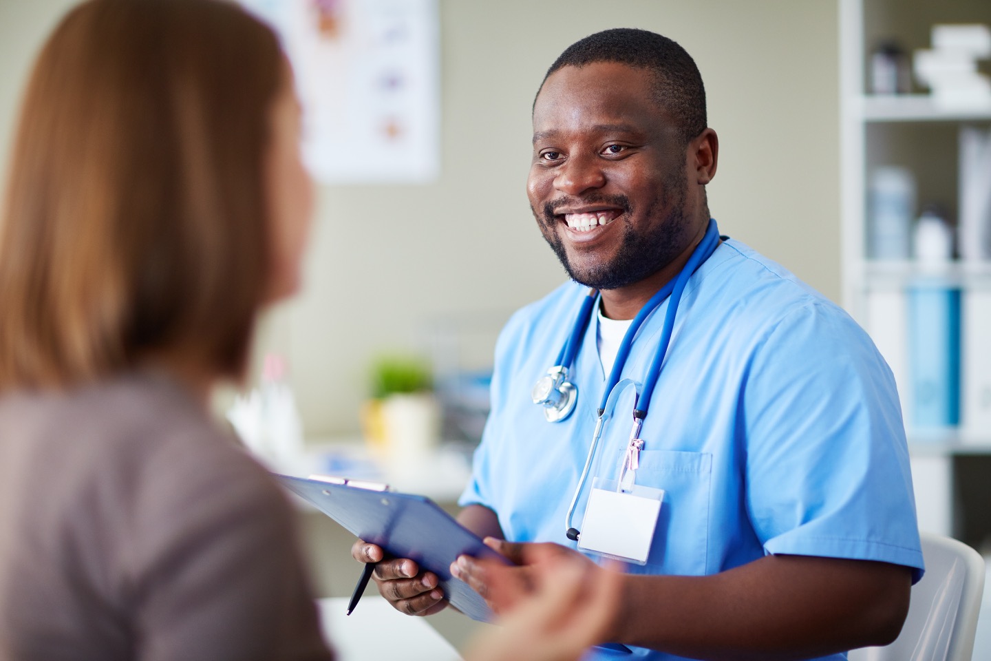 picture of medical student with clip board smiling at patient