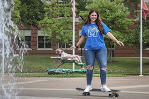 student riding skateboard by fountain