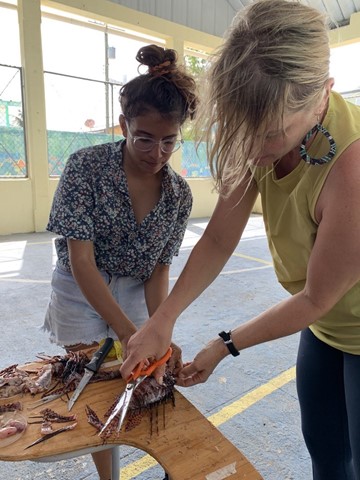 Keri Brondo and her research partner Andrea Izaguirre at a lionfish dissection workshop in Utila Cays for their National Geographic project.
