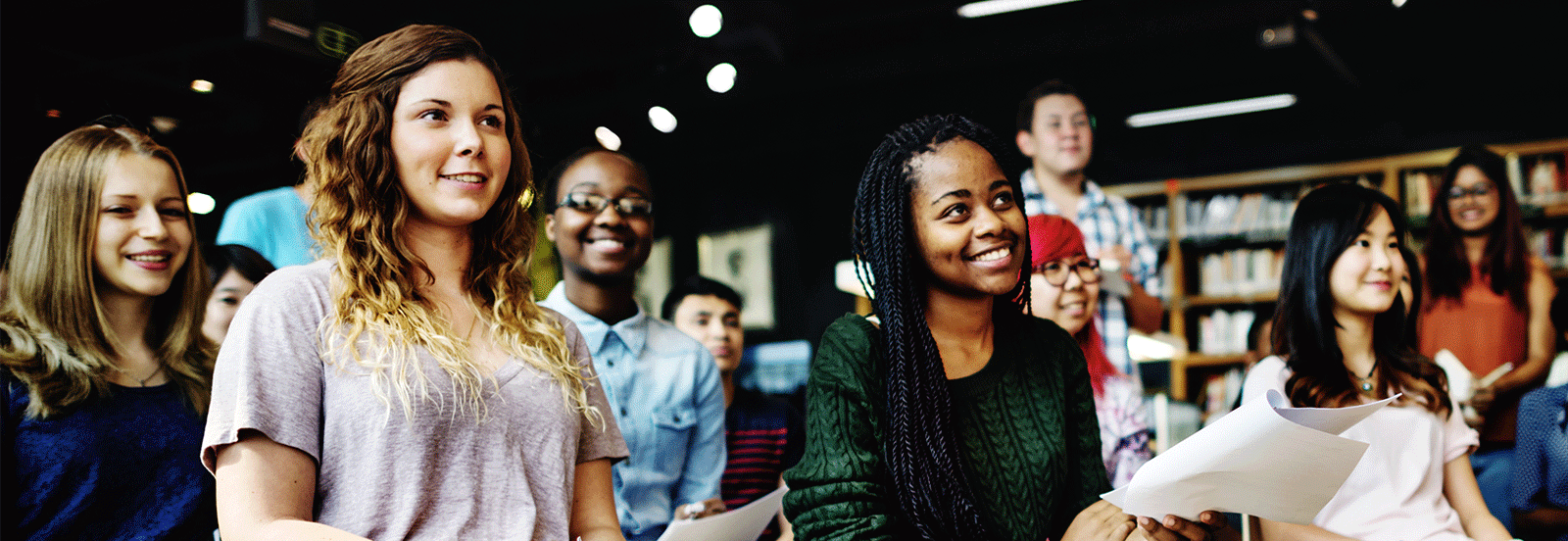 A diverse group of women attend a classroom like setting.