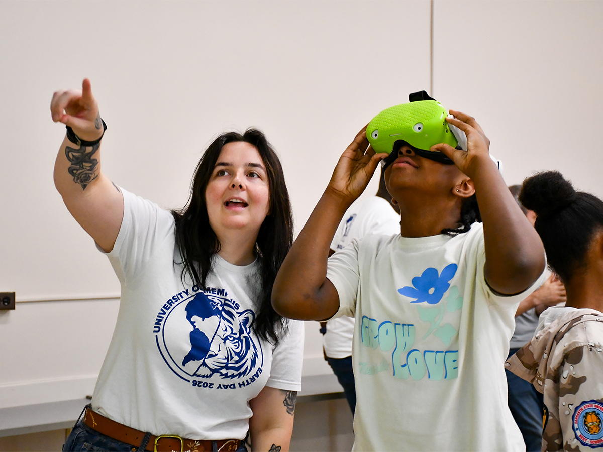 UofM Student Pointing Next to UMS Student Wearing VR Headset