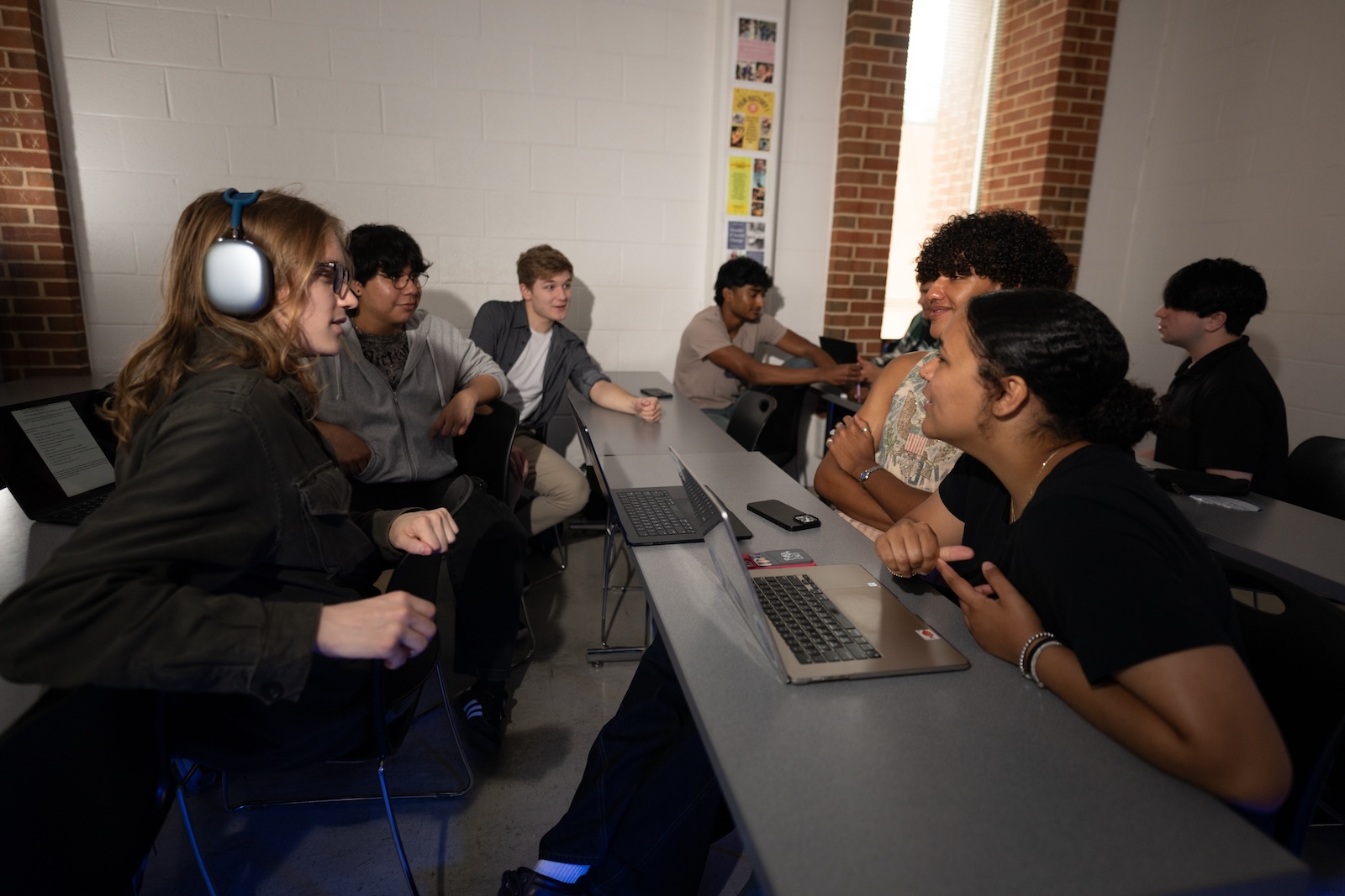 A group of sudents are talking in a classroom