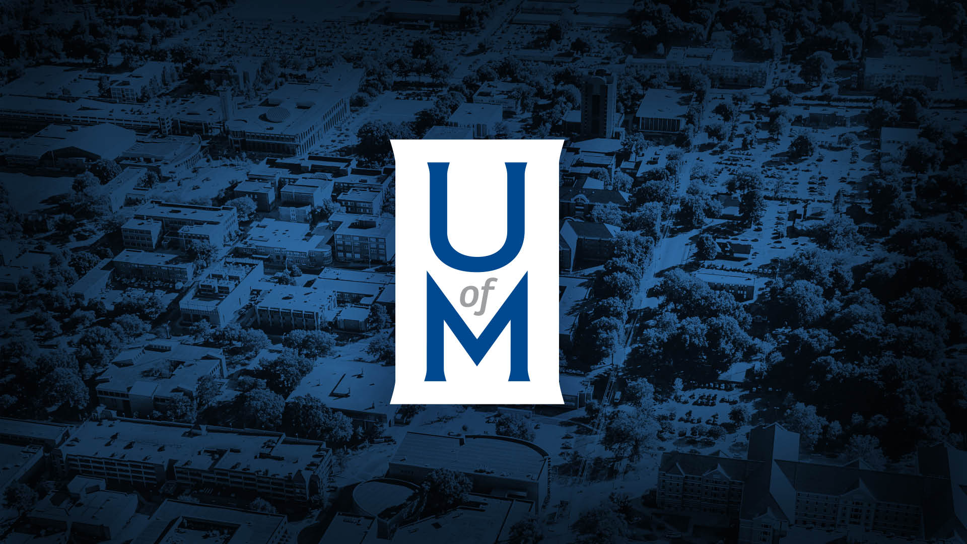 UofM logo over campus wallpaper