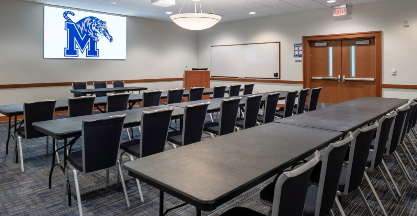 View of Poplar Room showing a classroom table setup and projection screen