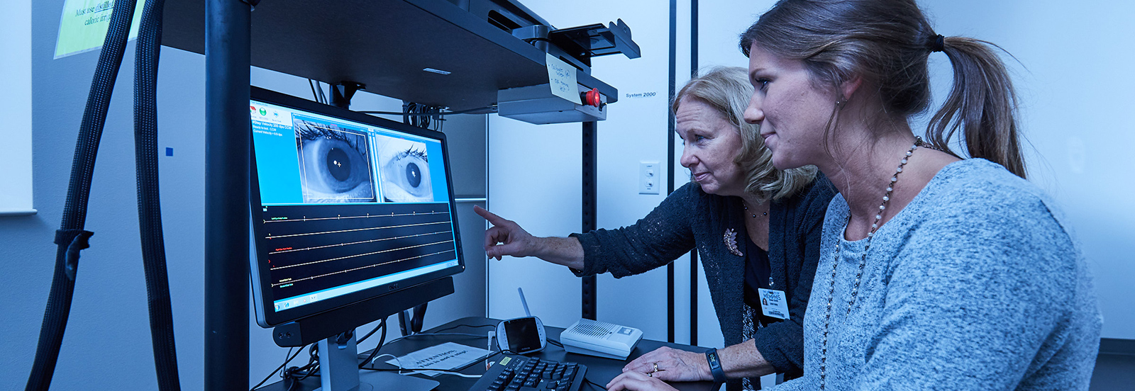 student and faculty member looking at eye research