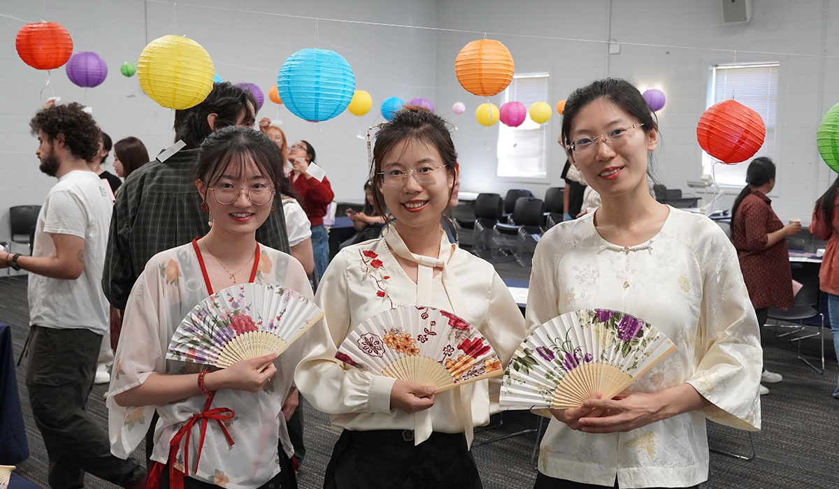 Three women holding paper fans