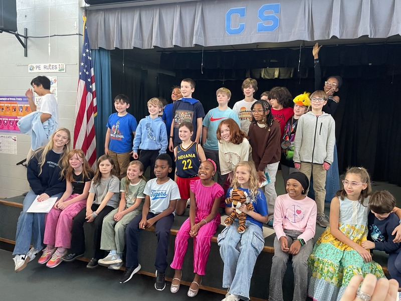 Ella Grace Decker poses with a group of Campus School students gathered on and in front of a stage.