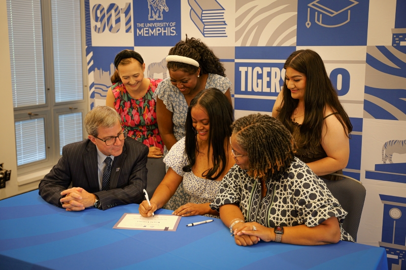 A student signs a Signing Day commitment document during a River City Partnership recognition event hosted by the University of Memphis College of Education.