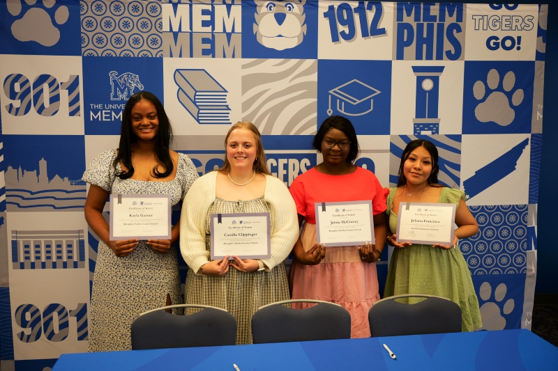 Recommended size: 800 × 600 px Four River City Partnership senior scholars stand together holding Signing Day commitment papers during a recognition event hosted by the University of Memphis College of Education.