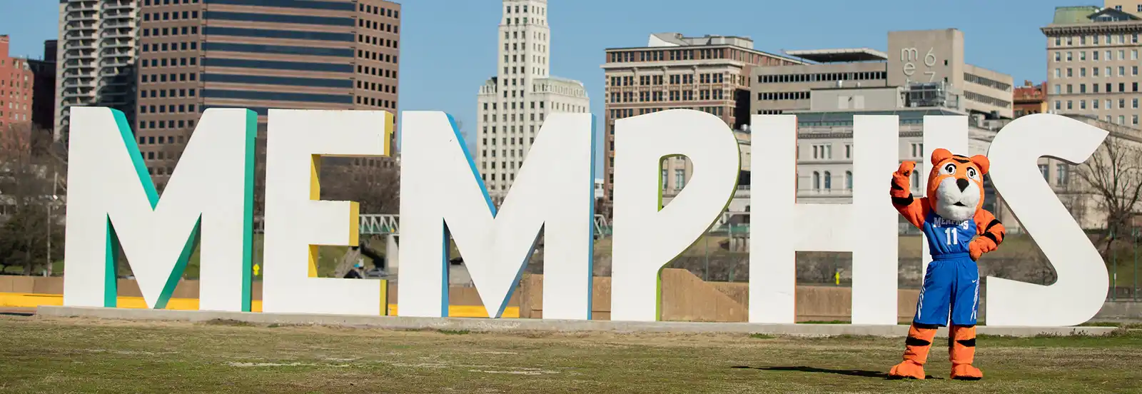 pouncer mascot standing in front of Memphis sign