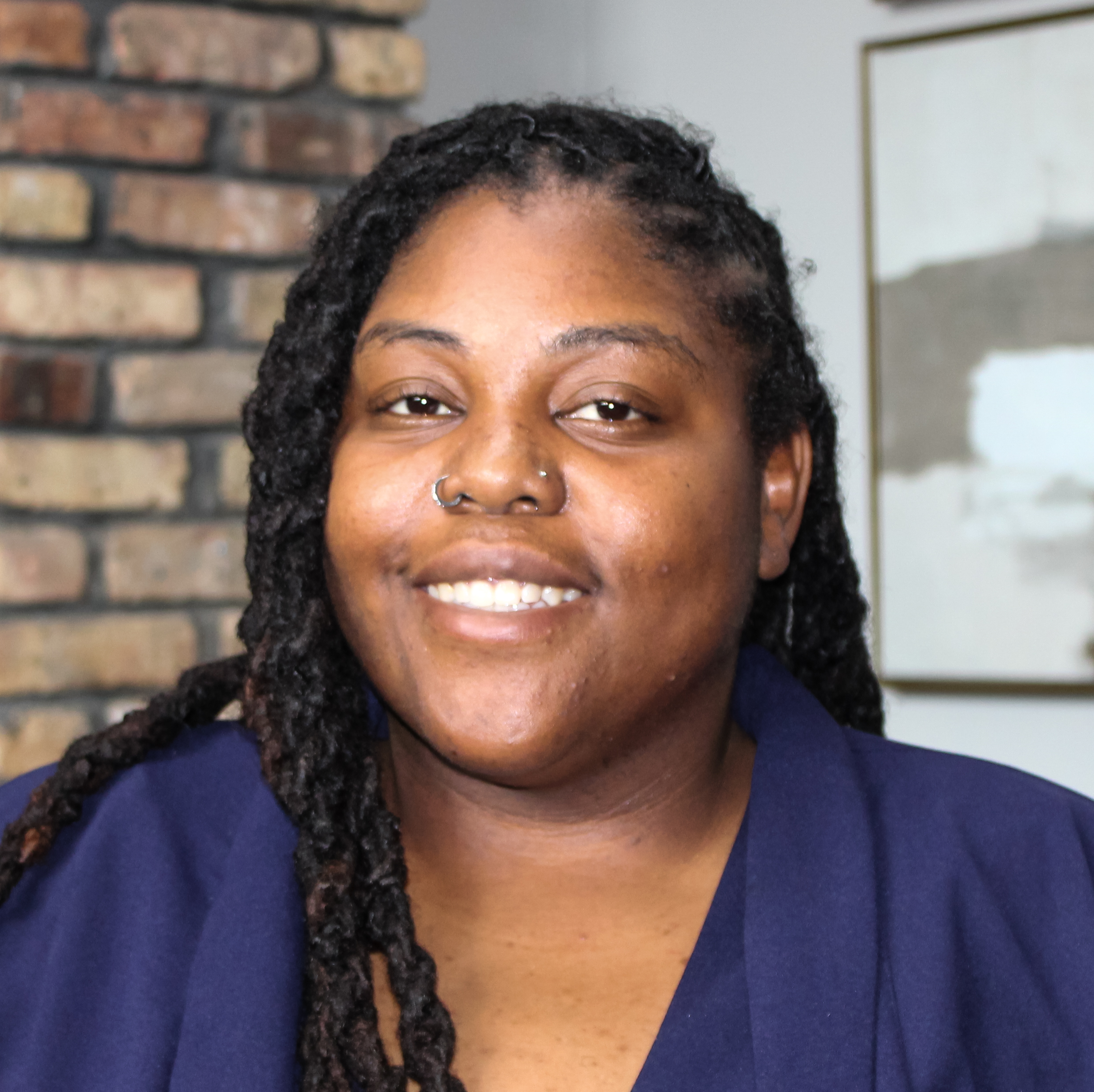Headshot of a black woman, wearing a dark blue business suit.