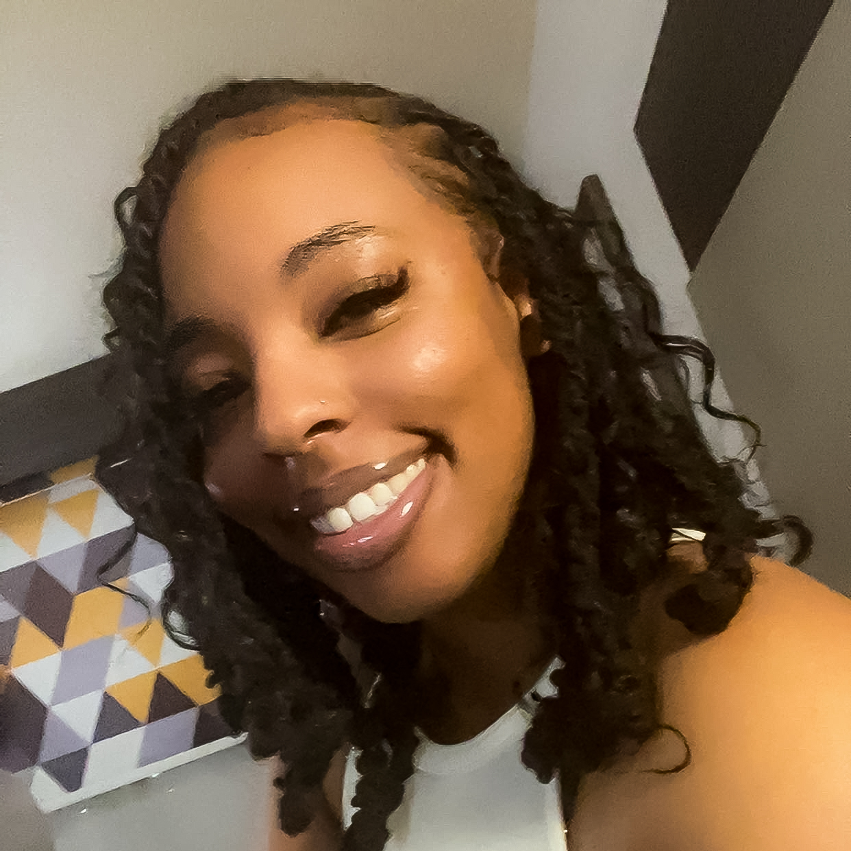 Head shot of African-American student, Daniqua. She's wearing a cream colored- shirt, smiling with braided hair.