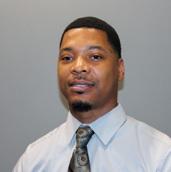 Headshot of Jermaine Clark, African-American man, wearing a collared shirt and tie.
