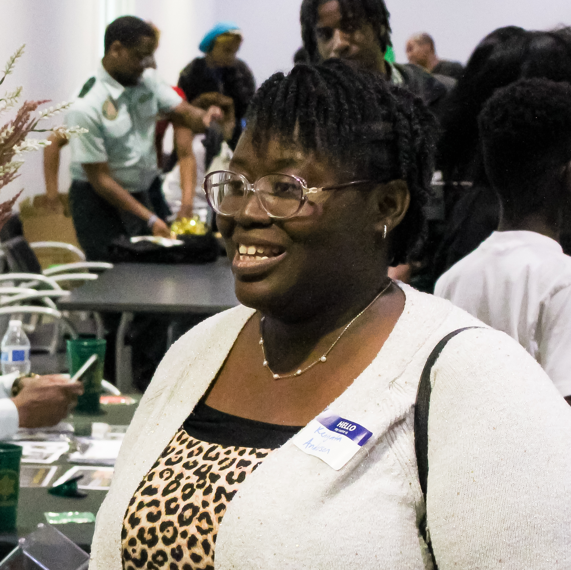 Photo of GROWWTH Participant Kenyata attedning the GROWWTH Job Fair. She is smiling while speaking to a vendor.