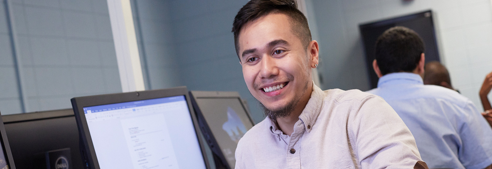 student with computers in background