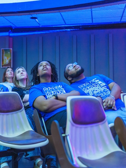 students watching a show at the planetarium