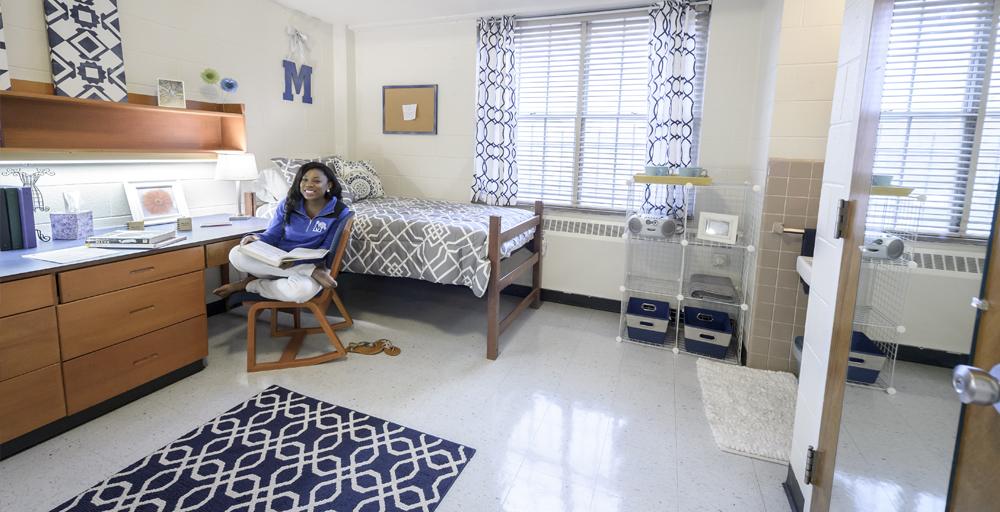 student relaxes in their Rawls Hall double bed dorm room