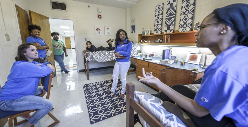 six students discussing, chatting in a Rawls Hall double bed room