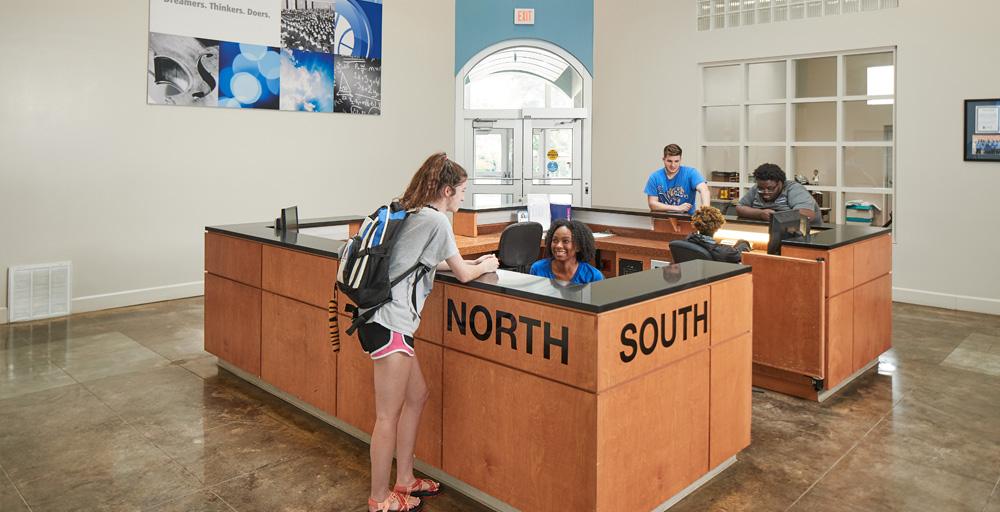 Living Learning Complex (LLC) Lobby/Front Desk area with student workers assisting residents.