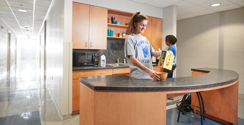 Two students creating meals within the Living Learning Complex (LLC) Kitchenette area.