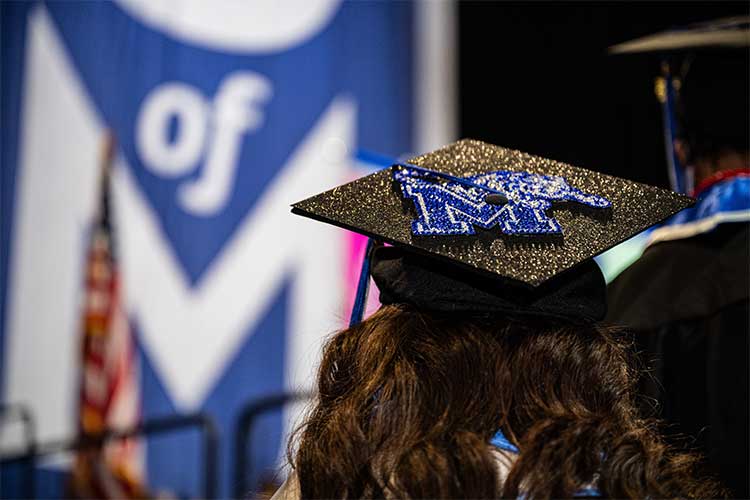 A graduating student shows Tiger spirit at a 2023 University of Memphis Commencement.