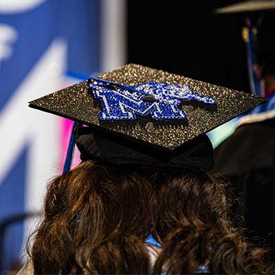 A graduating student shows Tiger spirit at a 2023 University of Memphis Commencement.
