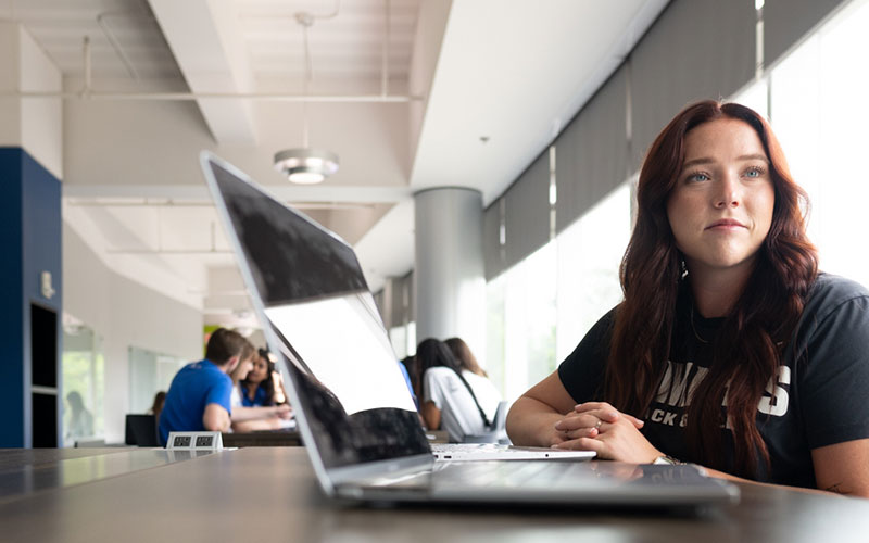 Female student sitting at desk with laptop