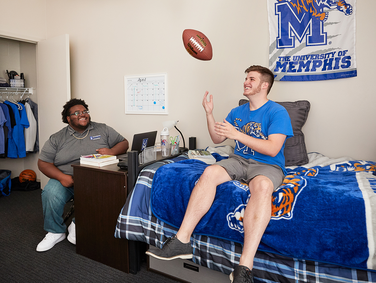 two male students hanging out in dorm room