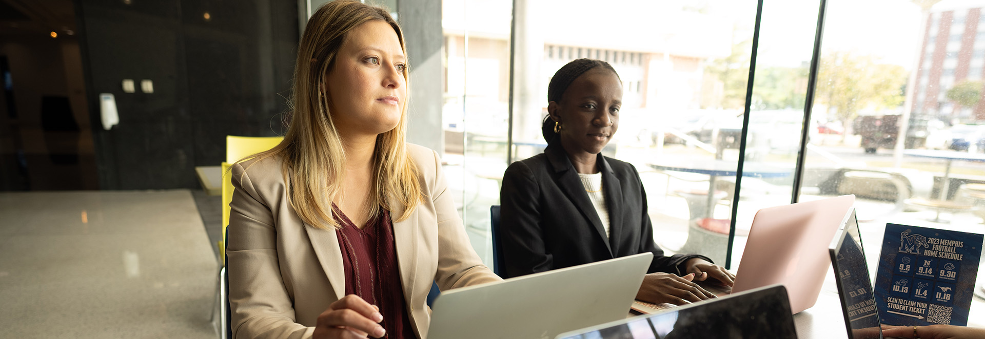 2 female students on laptops