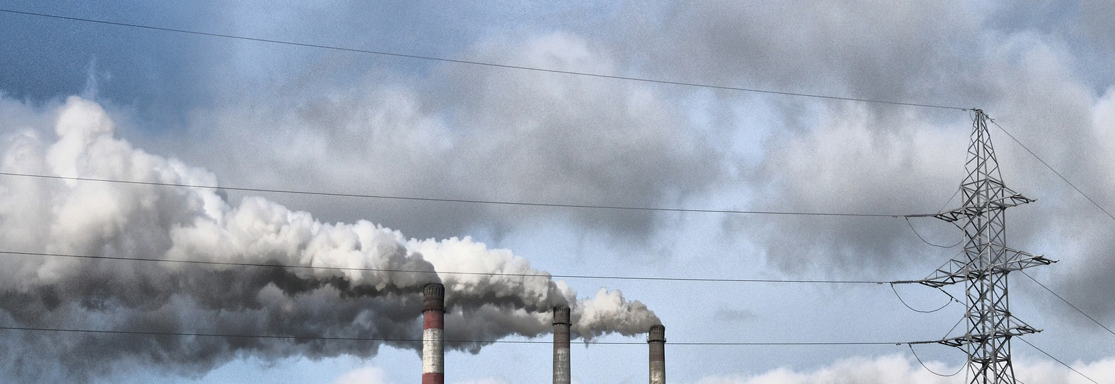 Thick smoke being thrown in the air from chimneys of powerhouses.