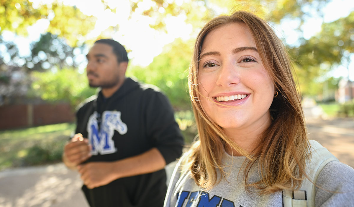 A male and female student walking on campus