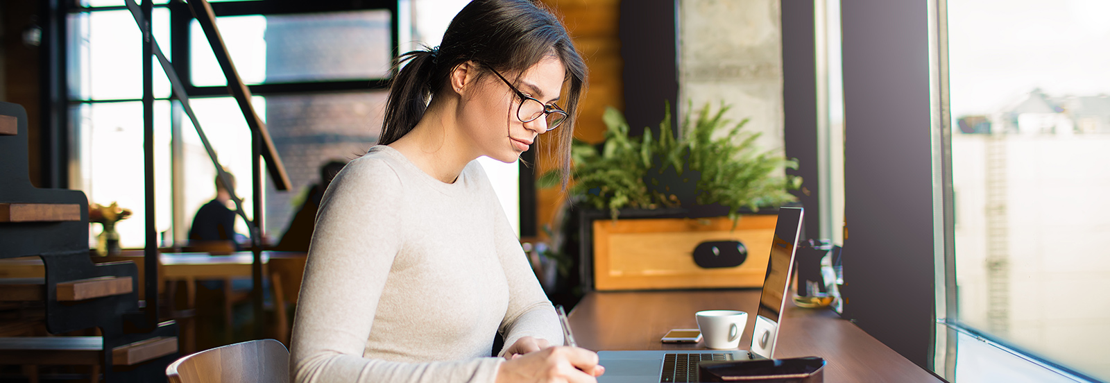 female working on laptop in coffee shop