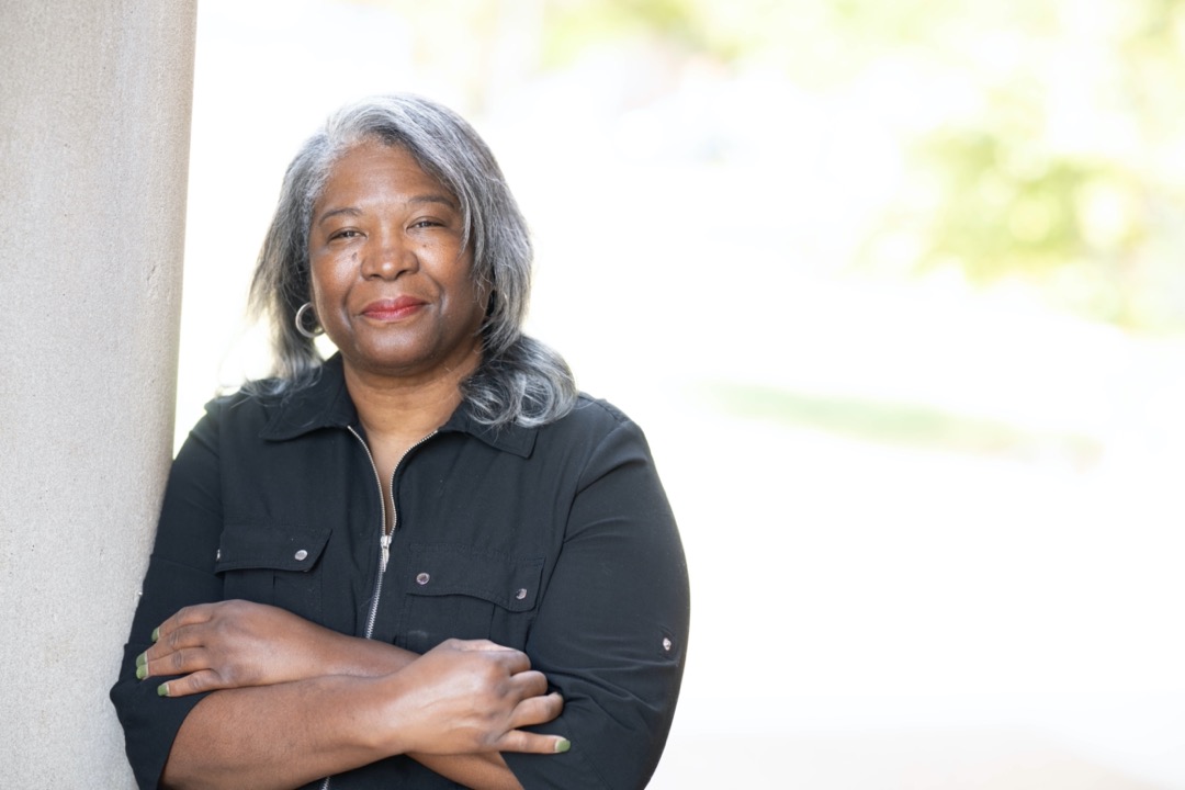 UofM Global Social worker smiling with arms crossed