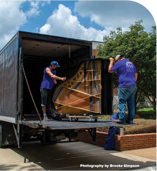 Photo of two men loading piano into truck - photo by Brooke Simpson