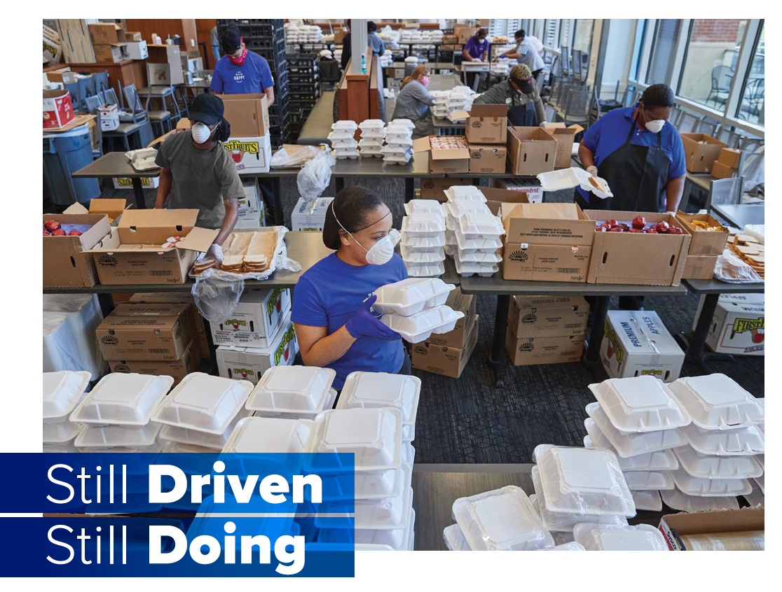 Still Driven. Still Doing. - UofM, Chartwells employees box food 