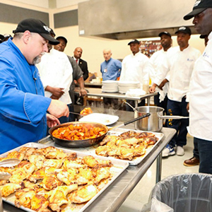 Chef William Mullins (left), leads a class at the Shelby County Corrections Department on Mullins Station Road. Mullins, a professor at the Kemmons Wilson Culinary Institute, teaches inmates enrolled in the U of M's culinary fundamentals course. (photo credit: Micki Martin/Martin Family Foundation)