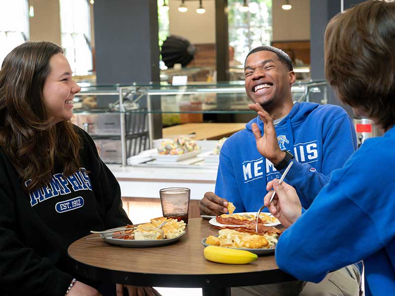 Students eating on campus and laughing
